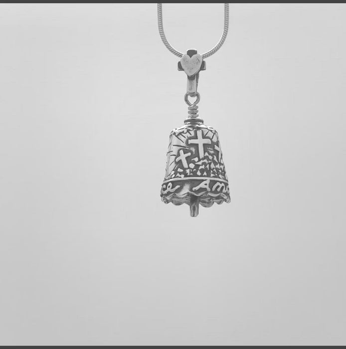 In this video you can see our handcrafted sterling ilver pendant, the Amazing Grace Bell Pendant. It features the three crosses of Calvary and a dove, with the Crown of Thorns going around the top of the bell. At the bottom are the words "Amazing Grace". The bail is a cross with a heart in the middle and the clapper is a Shepherd's hook.