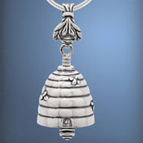 Handcrafted in Sterling Silver, the Bee Bell Pendant is shaped like a bee hive with bees flying around the hive. The clapper is a honey dipper and the bail is bee.