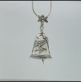 In this video you can see our handcrafted sterling silver Dragonfly Bell Pendant, Enchanting Us With Playful Acrobatics Handcrafted in sterling silver, this Dragonfly Bell Pendant features delicate dragonflies taking flight, the bail is a dragonfly and the clapper is a leaf with a tree frog clinging to it.