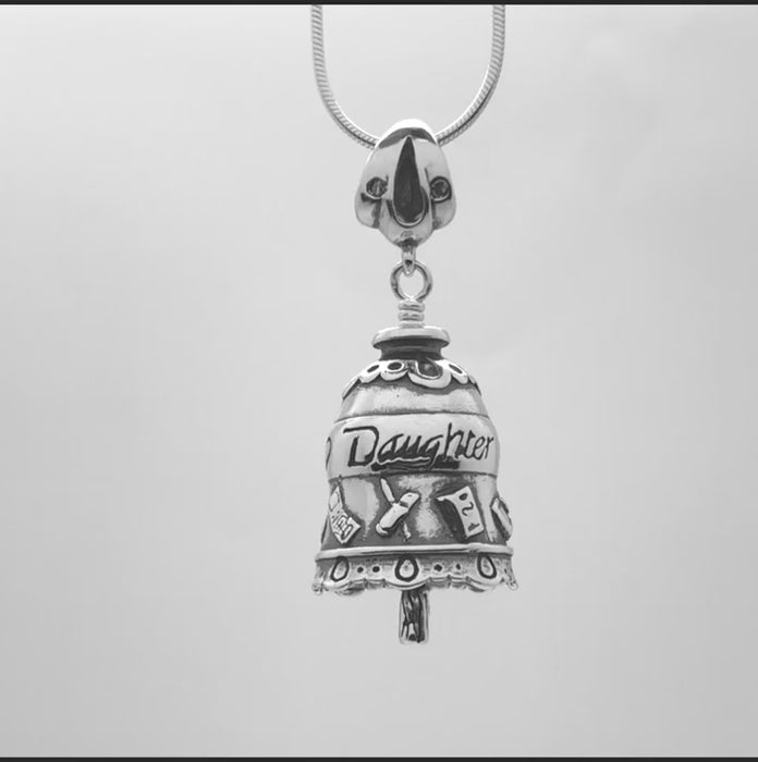  In this video you can see our handcrafted sterling silver necklace, the Daughter Bell. It is decorated with hearts and icons representing a cell phone, makeup, book, car, and doll. The clapper of this bell is a make-up brush.