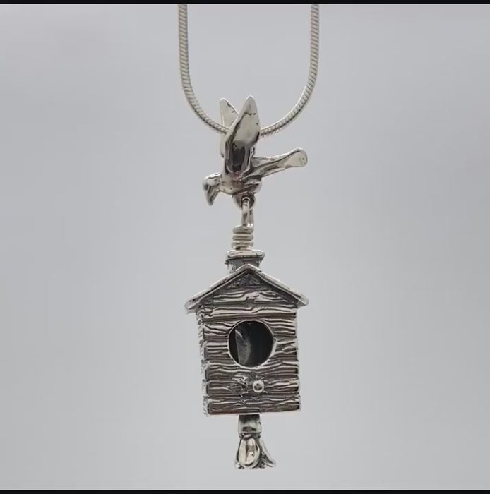 In this video you can see our handcrafted sterling silver Birdhouse Pendant,  the bail is a bird taking flight over the birdhouse while a flower blossom clapper gently rings this bell.