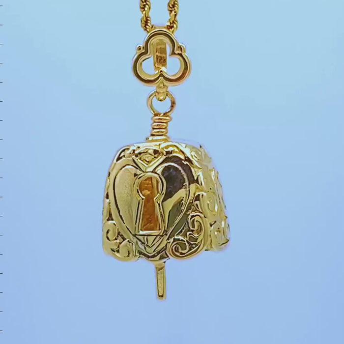 Handcrafted in 10 or 14K, this bell necklace is shaped like an antique padlock. There is a large heart with a key hole in its center on the both sides of the bell. The key is the clapper and the bail resembles the handle of a skeleton key.