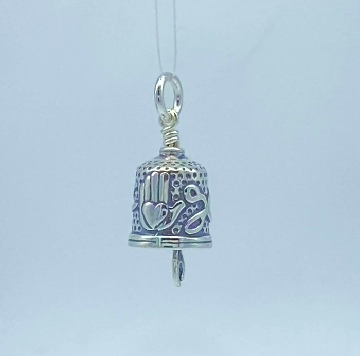 Handcrafted in sterling silver, the Quilting Hands Charm Bell is shaped like a thimble. Pinking shears and the heart in hand symbol decorate the sides, and a seam ripper hangs below to ring the bell.