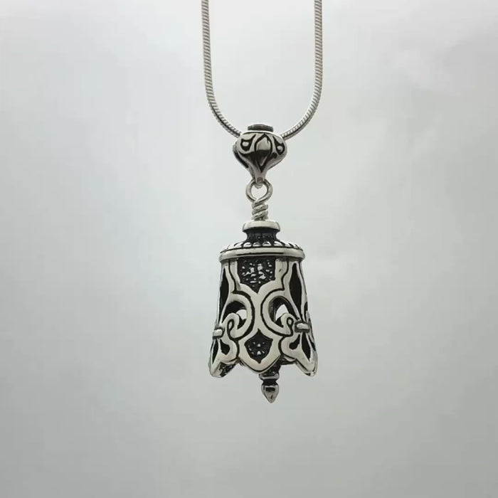 In this video you can see our handcrafted sterling silver Fleur de Lis Bell Pendant. The Fleur de Lis Bell Pendant is adorned with a bold Fleur de Lis design, accentuated by cutouts around the entire bell and the clapper is shaped like a finial.