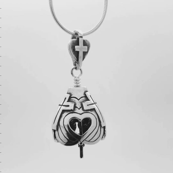 This video shows the  three sides, representing the Holy Trinity and three crosses representing the three crosses of Calvary on the God Loves You Bell Pendant. The open hearts remind us of His love. The bell's clapper is a cross with a heart at its center. The bail is a heart with a cross at its center.