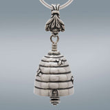 Handcrafted in Sterling Silver, the Bee Bell Pendant is shaped like a bee hive with bees flying around the hive. The clapper is a honey dipper and the bail is bee.