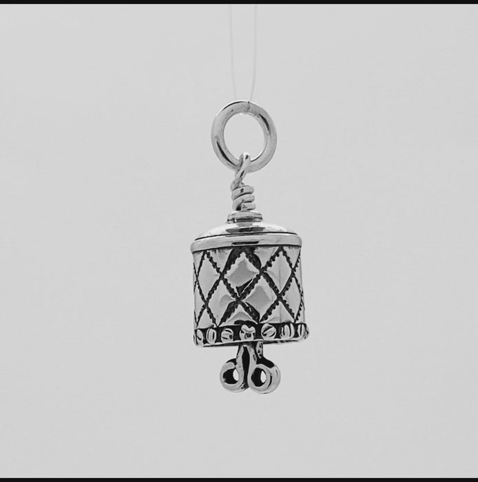 In this video you can see our handcrafted Sterling Silver Charm, the All Sewn Up Charm bell. The body features a quilt pattern with a button trim and the clapper is a pair of scissors.