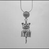 In this video you can see our handcrafted sterling silver Cat Pendant,  this Bell is unique because the cat's head turns, the only other bell that has this feature is the dog bell. The tail forms the clapper and the bail is a ball of yarn.