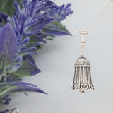 Handcrafted in Sterling Silver, the Comfort Bell Pendant is a gift with a unique design of woven hearts around the bottom.